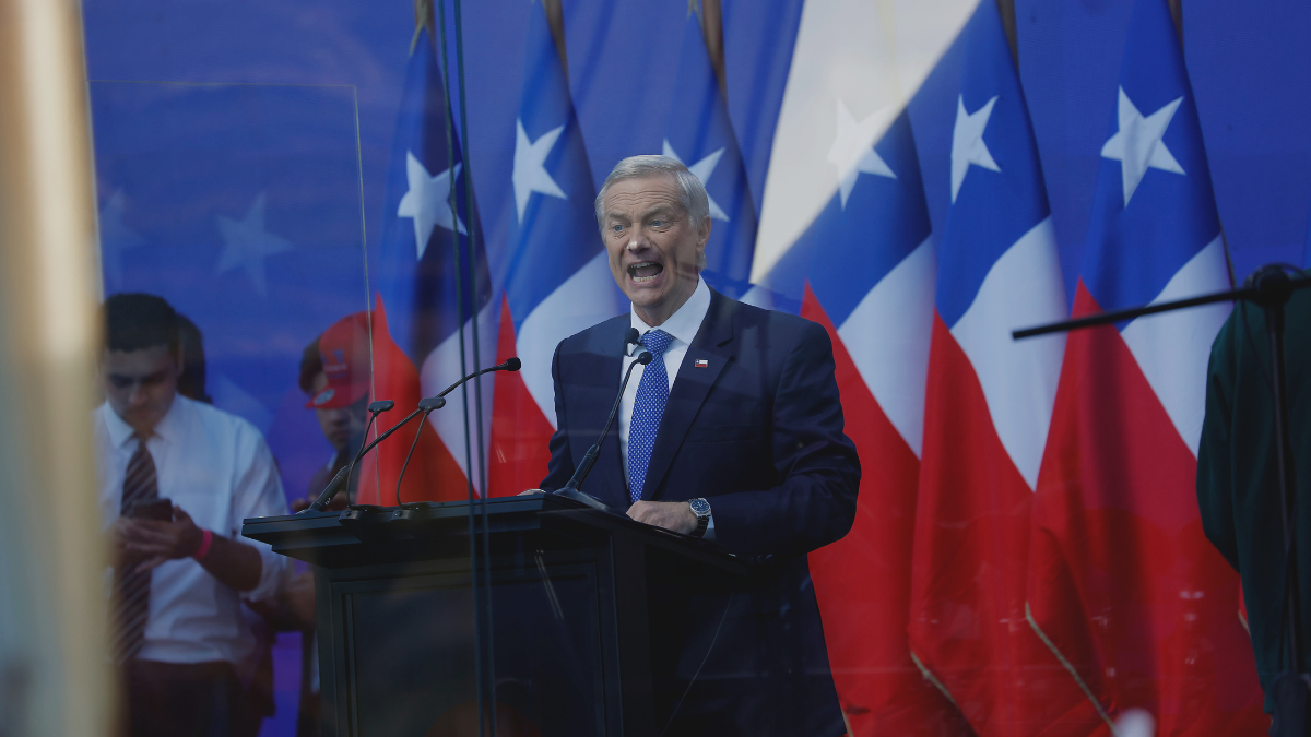 A person standing at a podium with flags behind him

AI-generated content may be incorrect.