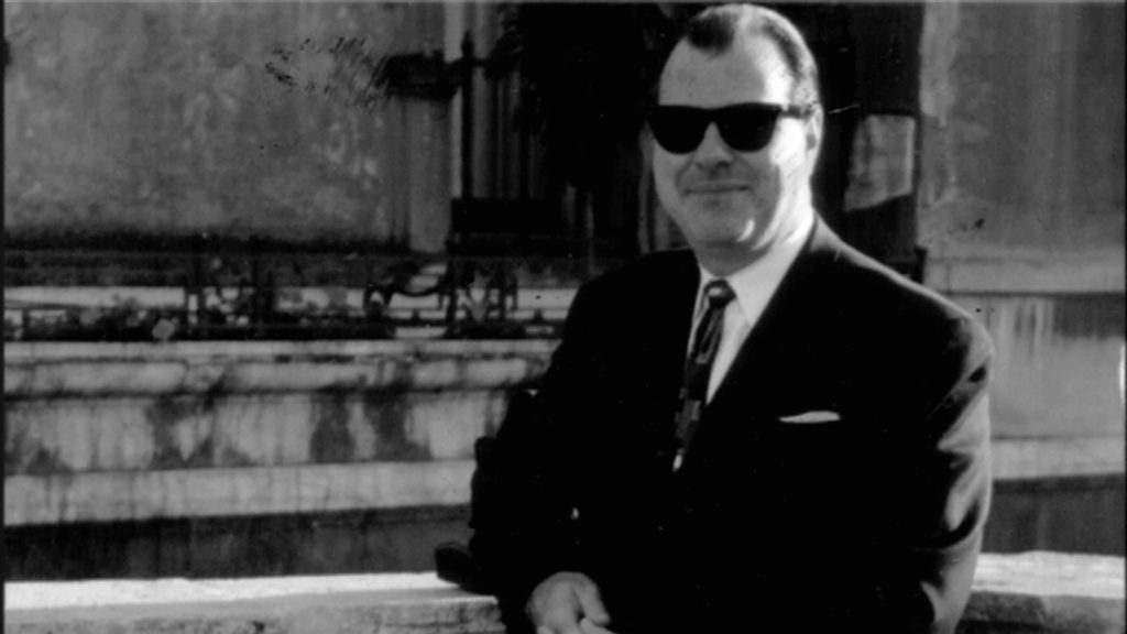 A person wearing sunglasses and a suit AI-generated content may be incorrect.