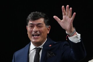 Chilean presidential candidate Franco Parisi waves upon arriving to take part in a presidential debate, in Santiago, Chile, Sept. 10, 2025. (AP Photo/Esteban Felix)