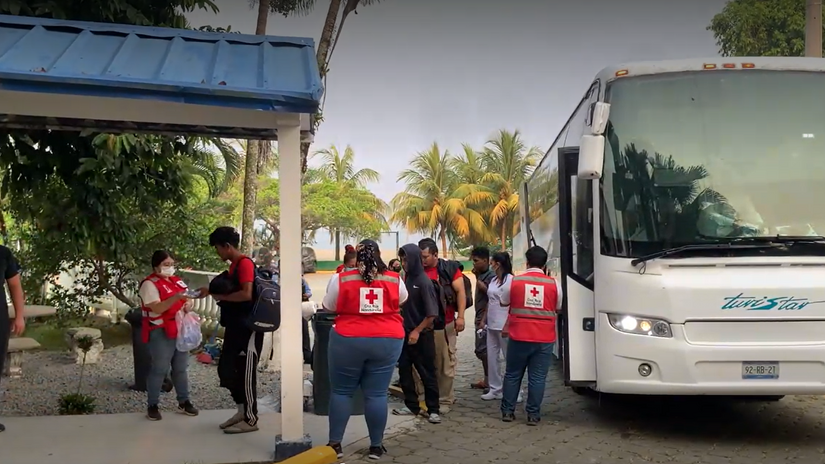 Honduran Red Cross volunteers greet people arriving by bus at the Centre for Attention to Returned Migrants (CAMR) in Omoa, north-west Honduras, where they will receive care and assistance.