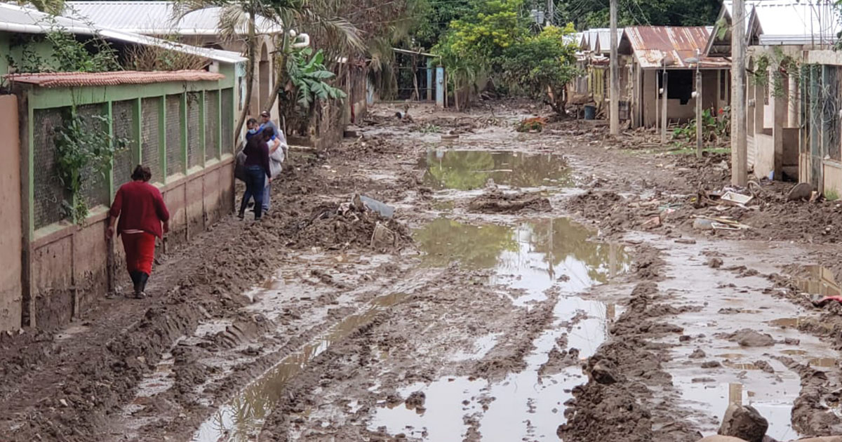 A muddy road with people walking

AI-generated content may be incorrect.