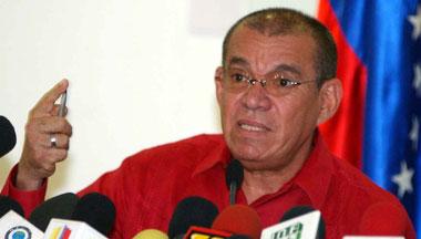 A person in a red shirt speaking into microphones

AI-generated content may be incorrect.