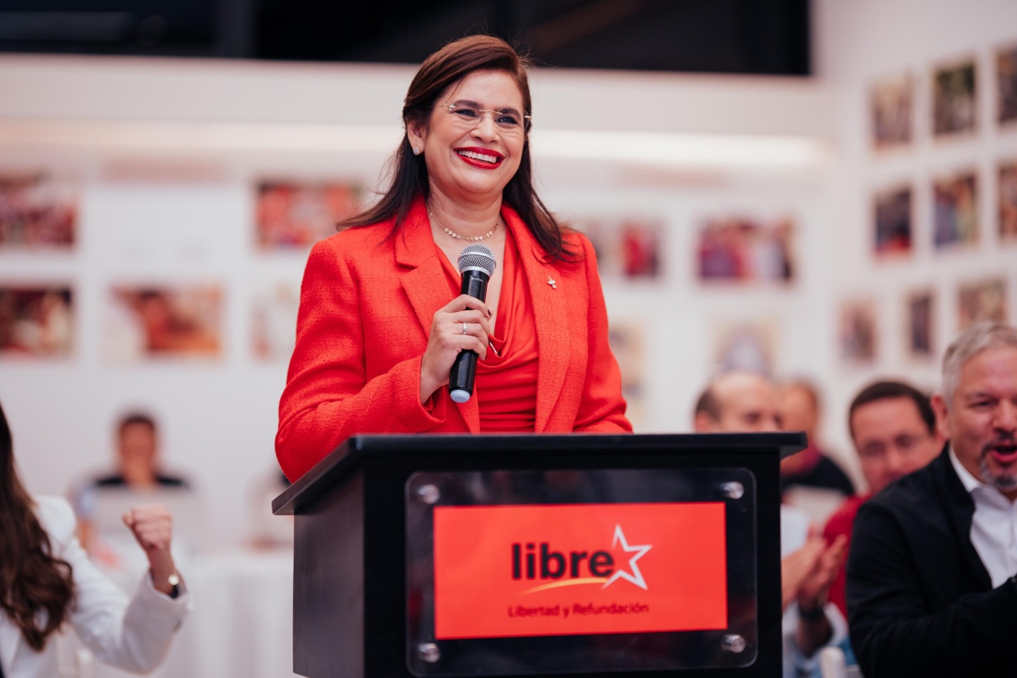 A person in a red suit speaking into a microphone

AI-generated content may be incorrect.