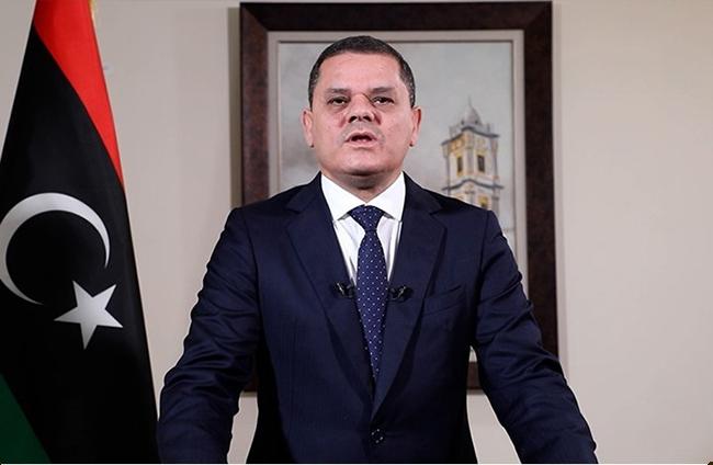 A person in a suit standing in front of a flag

AI-generated content may be incorrect.