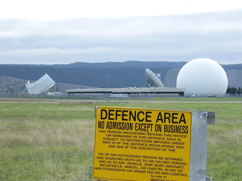 A yellow sign in front of a large satellite dish
AI-generated content may be incorrect.
