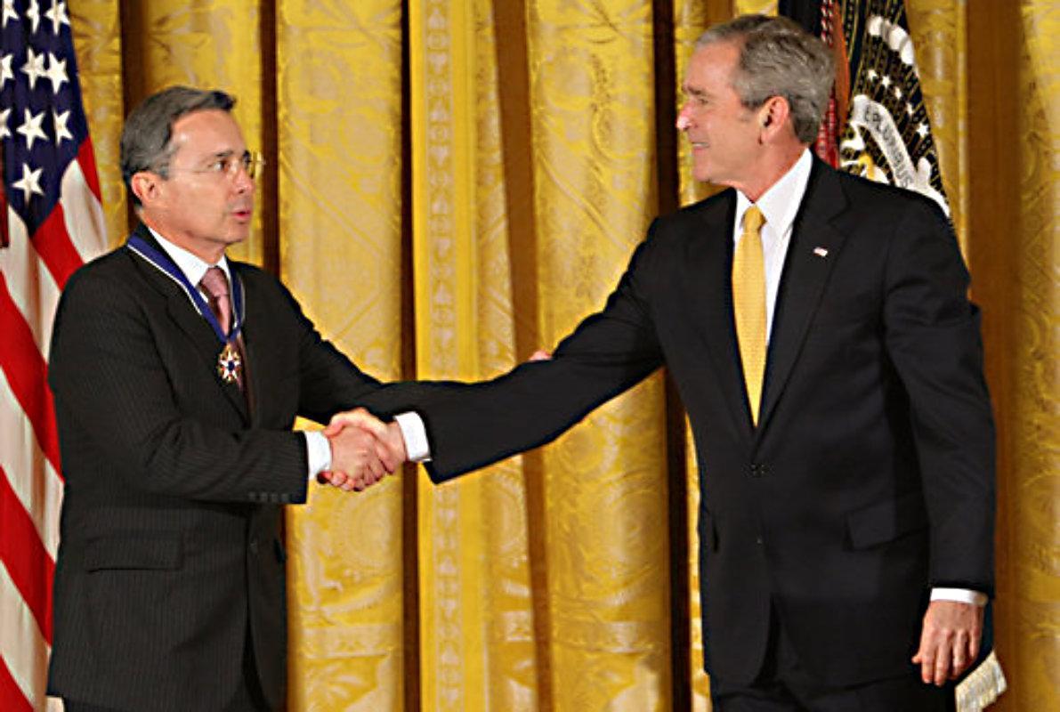 President George W. Bush congratulates President Alvaro Uribe of Colombia after presenting him with the 2009 Presidential Medal of Freedom Tuesday, Jan. 13, 2009, during ceremonies in the East Room of the White House