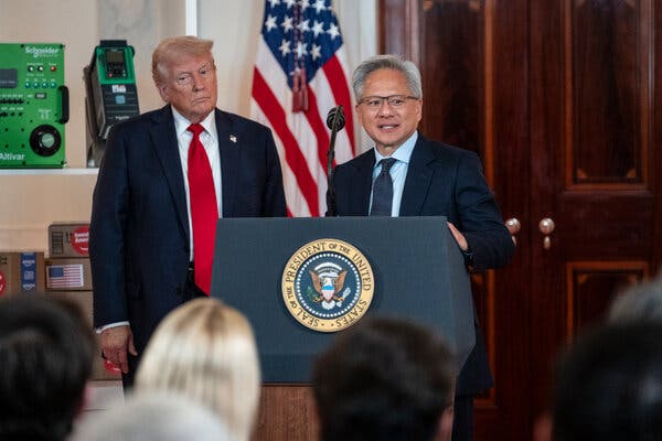 President Trump listens while Jensen Huang speaks at a lectern.