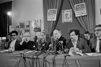 A group of men sitting at a table with microphones

AI-generated content may be incorrect.