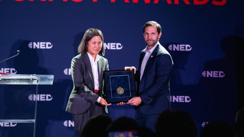 A person and person holding a plaque
AI-generated content may be incorrect.