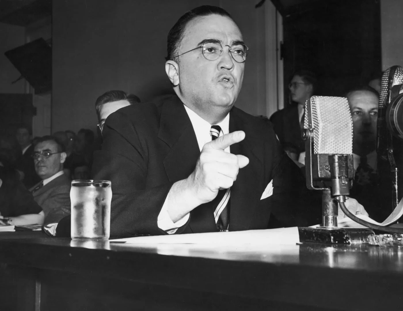 A person in a suit speaking into a microphone

AI-generated content may be incorrect.