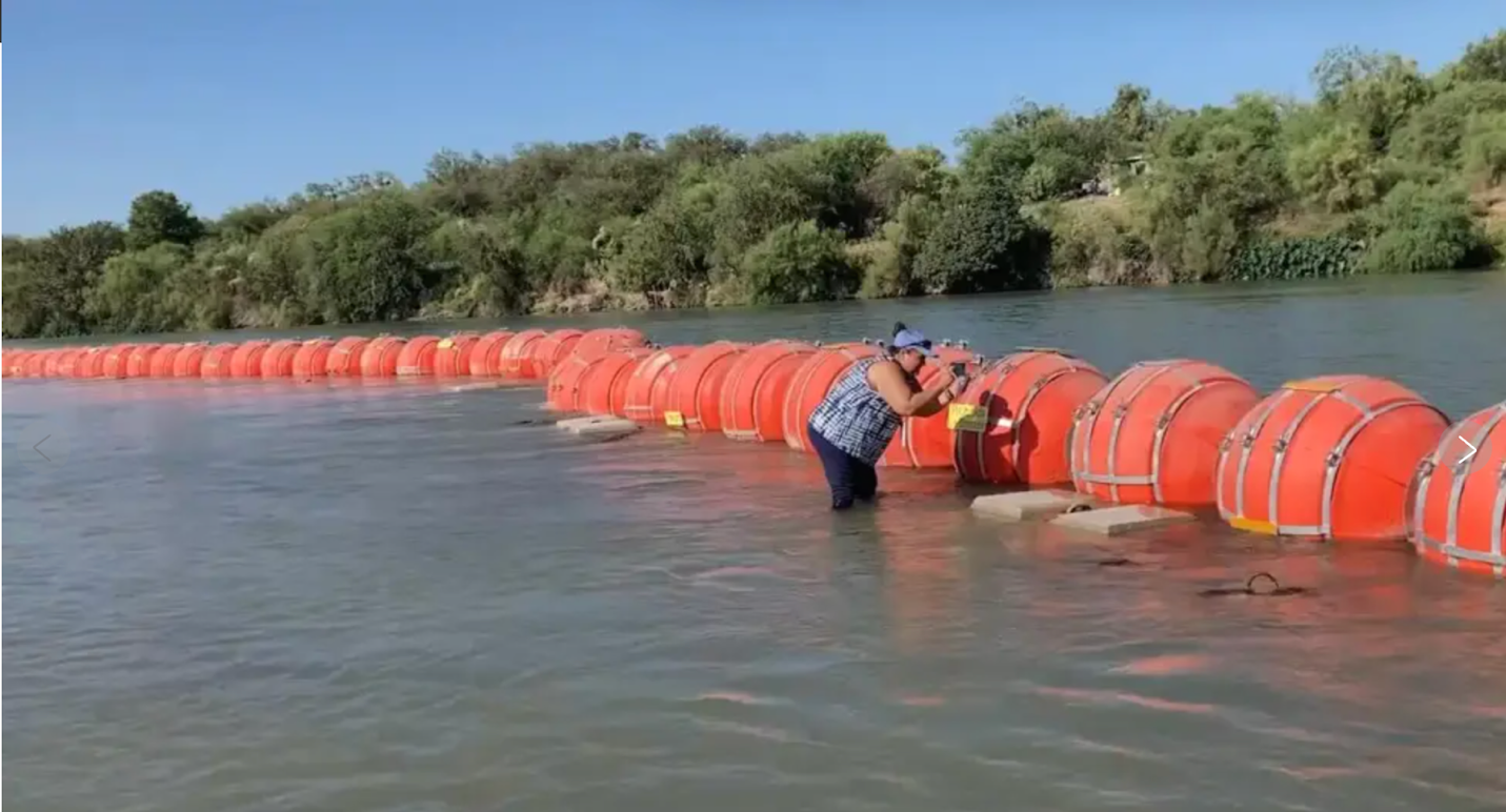 A person standing in water with orange barrels

AI-generated content may be incorrect.