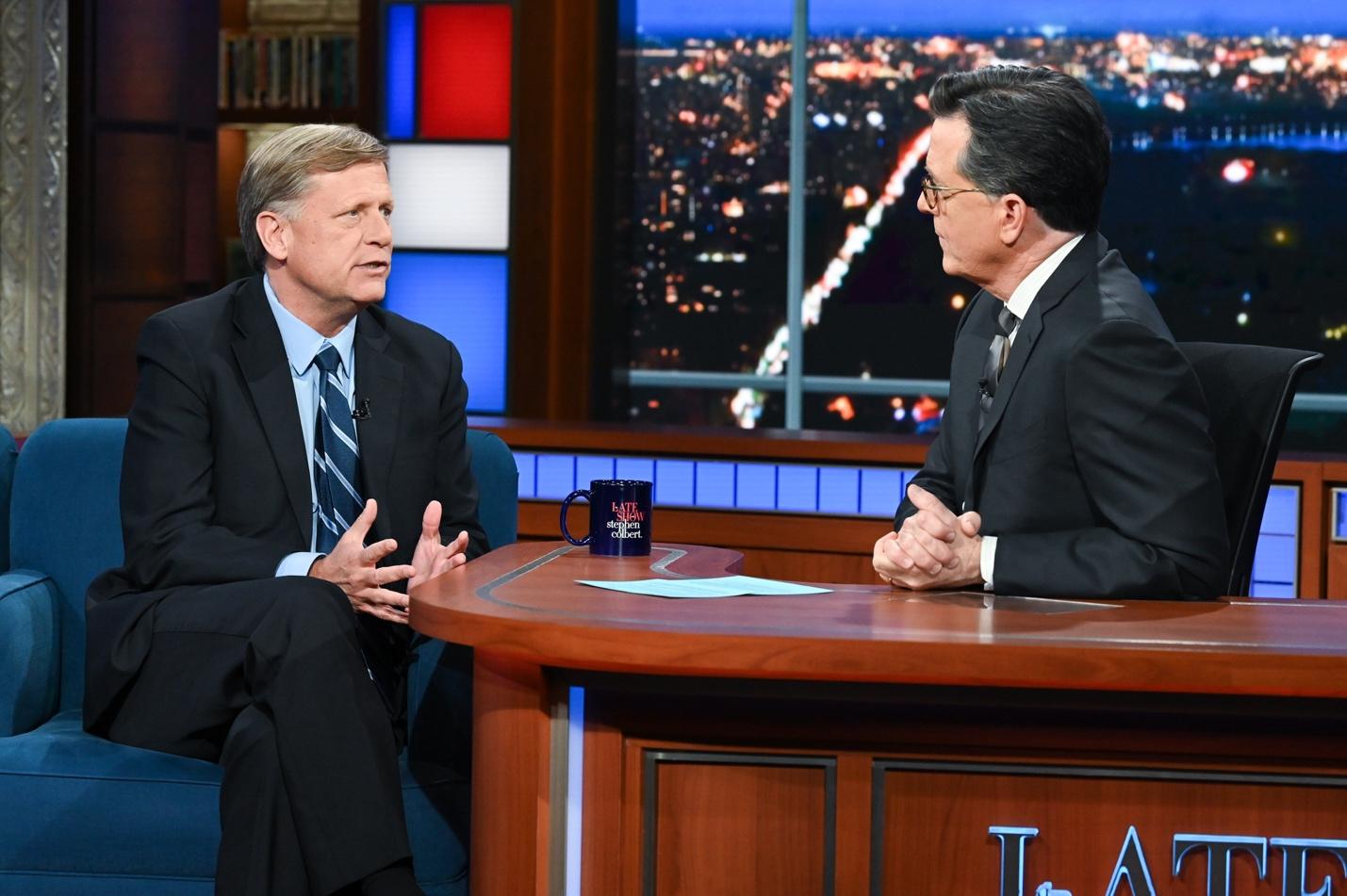 A person in a suit sitting at a table with another person in a suit sitting at a table

AI-generated content may be incorrect.