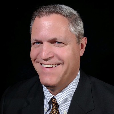 A person in a suit smiling

AI-generated content may be incorrect.