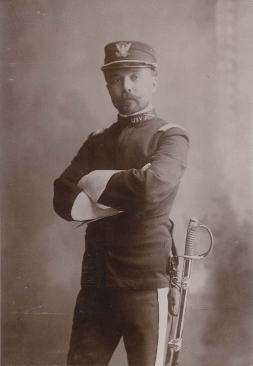 A person in uniform with arms crossed

AI-generated content may be incorrect.