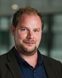 A person with a beard and mustache

Description automatically generated