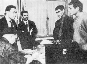 A group of men standing around a table

AI-generated content may be incorrect.