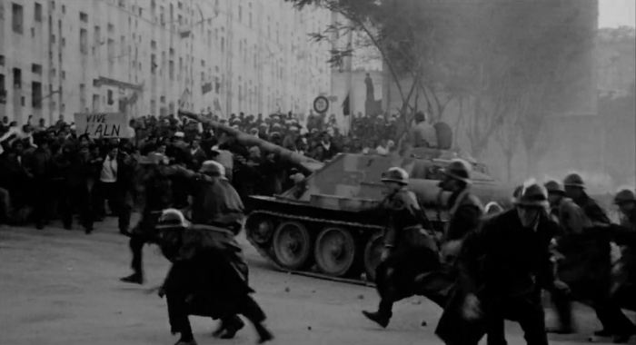 A group of people running on a street with tanks

AI-generated content may be incorrect.