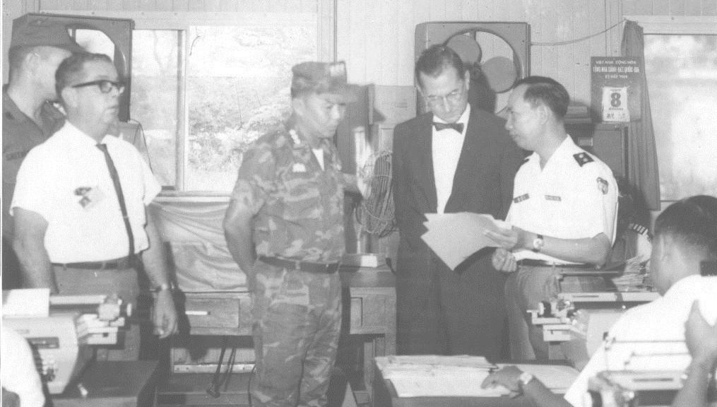 A group of people standing around a table

Description automatically generated