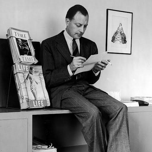 A person sitting on a desk writing on a piece of paper

Description automatically generated