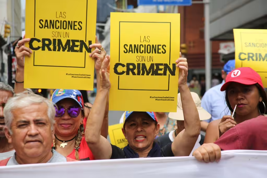 Venezuelans march in Caracas with posters that say "Sanctions are a crime." Photo: VTV.