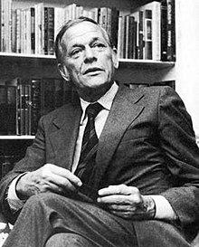 A person in a suit sitting in front of a bookcase

AI-generated content may be incorrect.