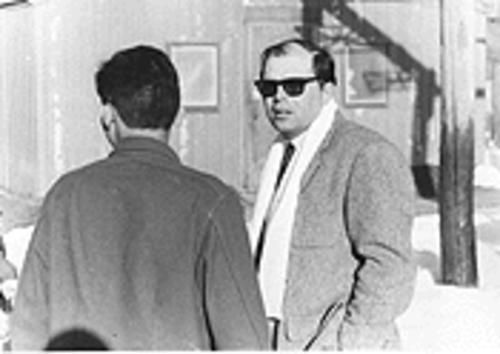 A person wearing sunglasses and a suit talking to another person

AI-generated content may be incorrect.