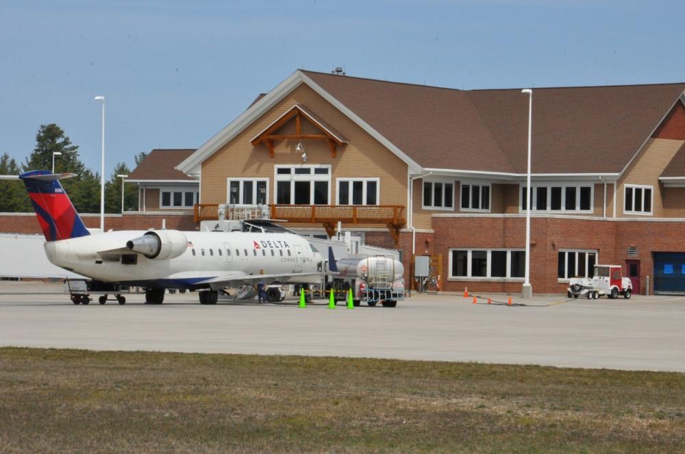 A plane parked in front of a building

AI-generated content may be incorrect.
