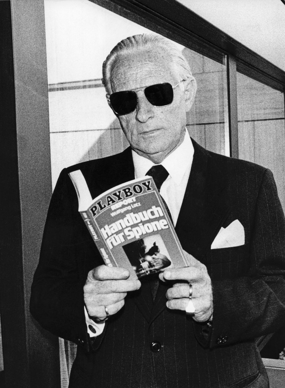 A person in a suit holding a book
AI-generated content may be incorrect.