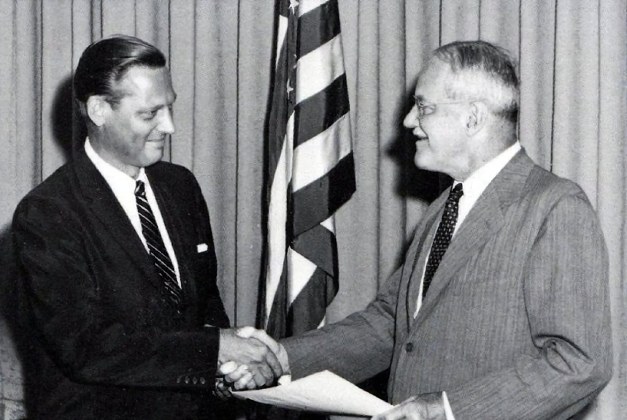 Men shaking hands with a flag

AI-generated content may be incorrect.