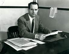 A person sitting at a desk with papers on it

Description automatically generated