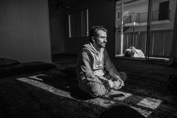 Iqbal sitting in front of a window with his legs crossed and his hands in his lap.