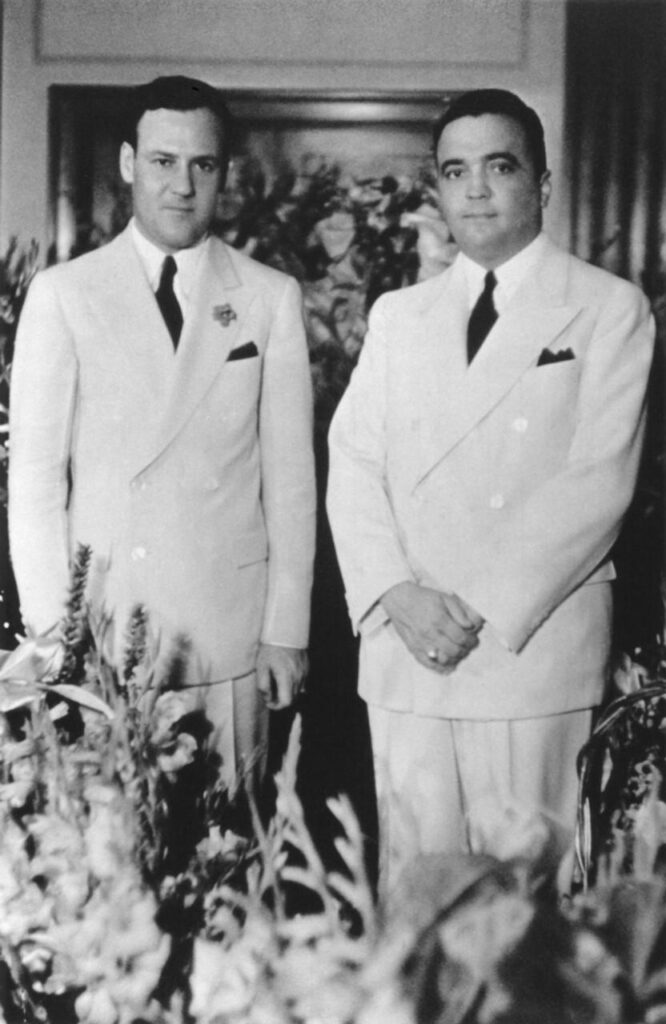 A couple of men in suits

AI-generated content may be incorrect.