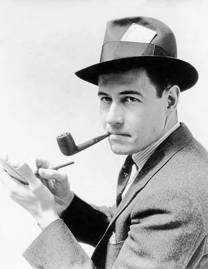 A person in a hat smoking a pipe
AI-generated content may be incorrect.