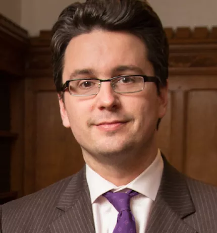A person in a suit and tie

AI-generated content may be incorrect.