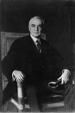 A person in a suit sitting in a chair
AI-generated content may be incorrect.