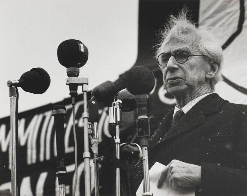 A person standing behind microphones

AI-generated content may be incorrect.