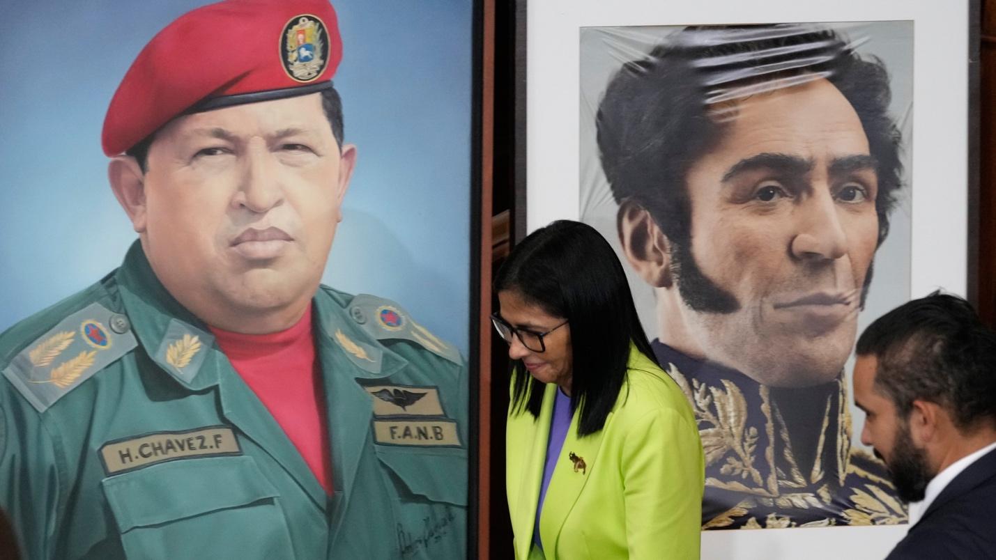 FILE - Venezuela's acting President Delcy Rodriguez walks past a image of former President Hugo Chavez, left, and Independence hero Simon Bolivar at the National Assembly in Caracas, Venezuela, Jan. 15, 2026. (AP Photo/Ariana Cubillos, File)