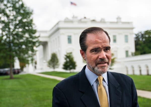 Mauricio Claver-Carone, wearing a dark suit and a yellow tie, standing outside the White House in August 2020.